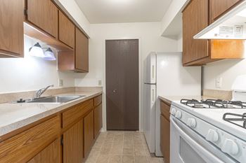 A kitchen with wooden cabinets and white appliances